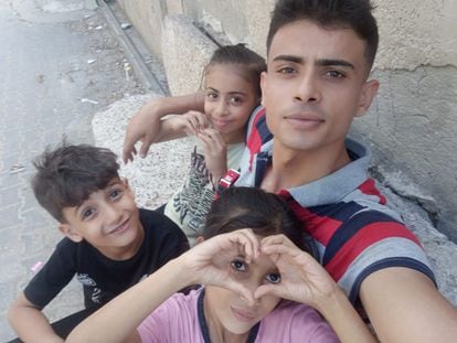 Abdallah Aljazzar, observado desde hace 24 años, en una foto con sus hermanos pequeños, la misma que utilizó para recaudar fondos para poder marchar en Australia.