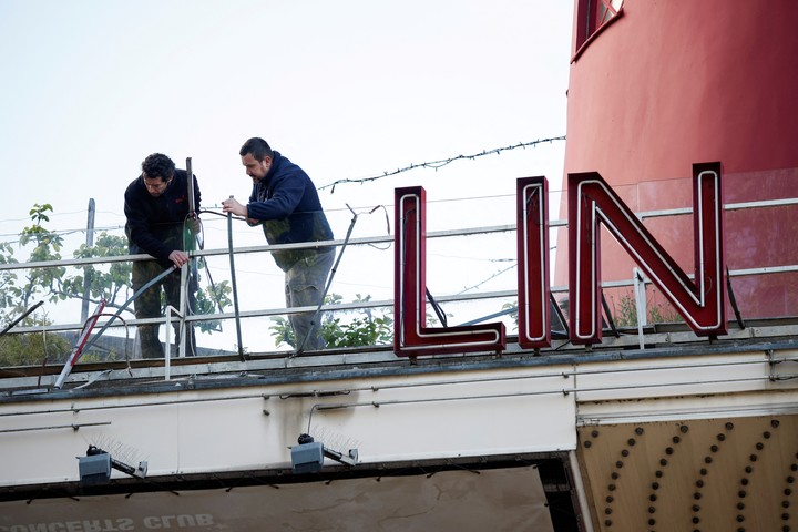 Los empleados intentan ensuciar el resto de la fachada del famoso cabaret.  Foto: Reuters