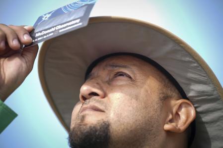 Fransisco Vielma, director de ciencias y estudios sociales de Eagle Pass ISD, observa el sol antes de un eclipse solar total el 8 de abril de 2024 en el Centro de Actividades de Aprendizaje de Eagle Pass en Eagle Pass, Texas. (Jon Shapley/Houston Chronicle vía AP)