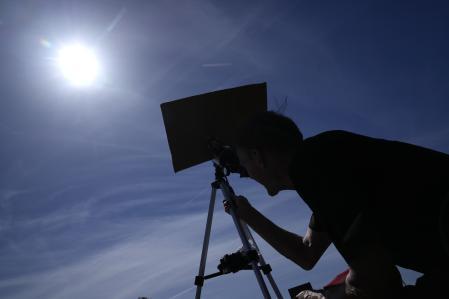 Mike Porter usa un telescopio para observar el sol mientras se prepara para observar un eclipse solar lunar total el 8 de abril de 2024 en Carbondale, Illinois.