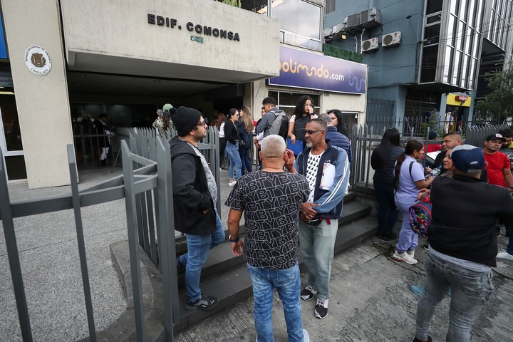 Ciudadanos venezolanos esperan información en las puertas del consulado de Venezuela en Quito.  Foto EFE