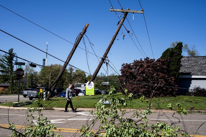 Un residente camina entre cables eléctricos después de que un tornado azotara el área de Portage, Michigan, EE.UU.  REUTERS/Emily Elconin.