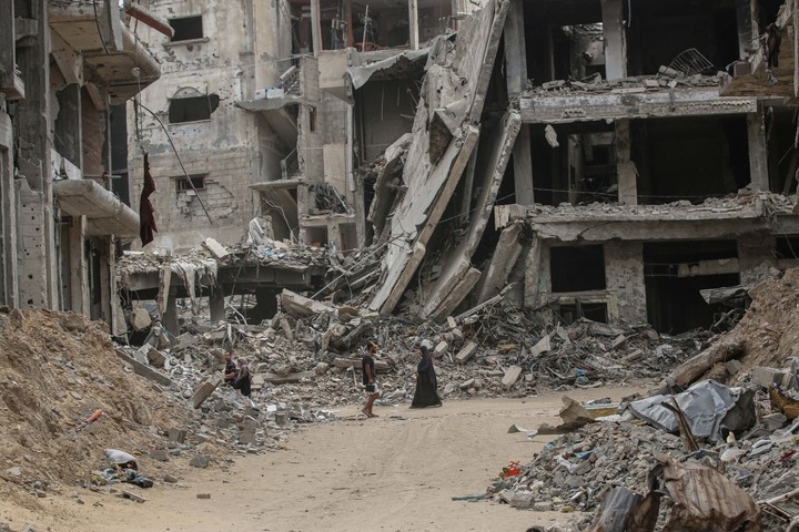 Los palestinos se encuentran entre las ruinas de Khan Younis, en el sur de Gaza, bajo el fuego israelí.  Foto de : BLOOMBERG