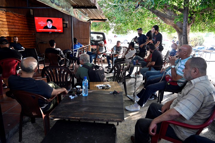 Un grupo de personas ataca al secretario general de Hezbolá, Hassan Nasrallah, mientras pronuncia un discurso por televisión en un café de un suburbio de Beirut, Líbano. Foto EFE