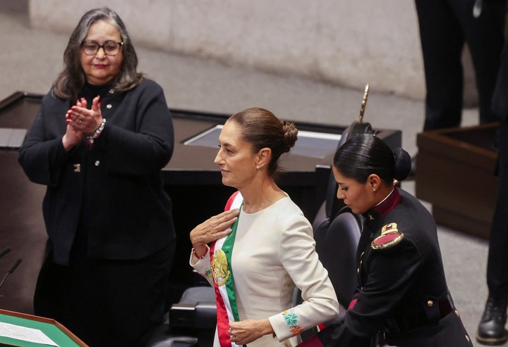 La nueva presidenta de México, Claudia Sheinbaum, observa cómo coloca la banda mientras la presidenta de la Suprema Corte de Justicia, Norma Pina, aplaude durante la ceremonia del jurado. FotoReuters