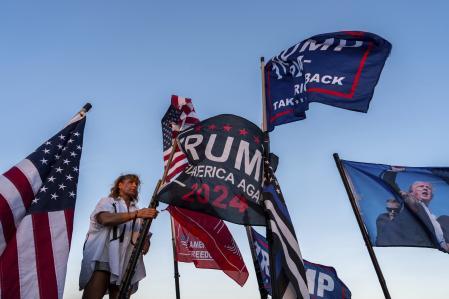Nikki Fuller, de 56 años, instala banderas en su camioneta cerca de la finca Mar-a-Lago del presidente electo Donald Trump, el lunes 11 de noviembre de 2024, en Palm Beach, Florida (Foto AP/Julia Demaree Nikhinson)