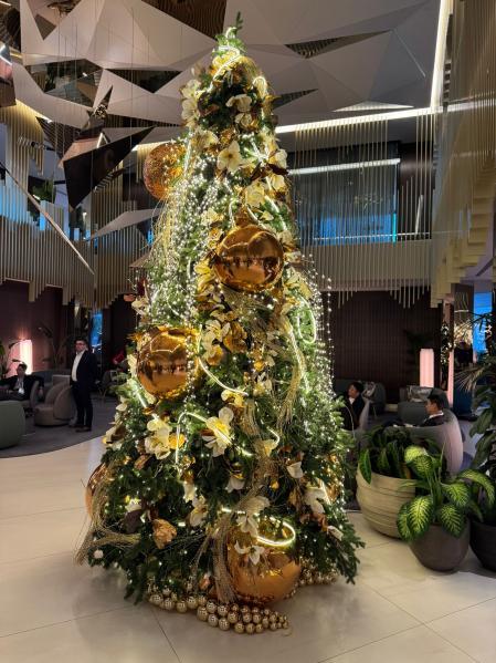 Luces, bolas doradas y flores amarillas en esta creación para el lobby de un hotel