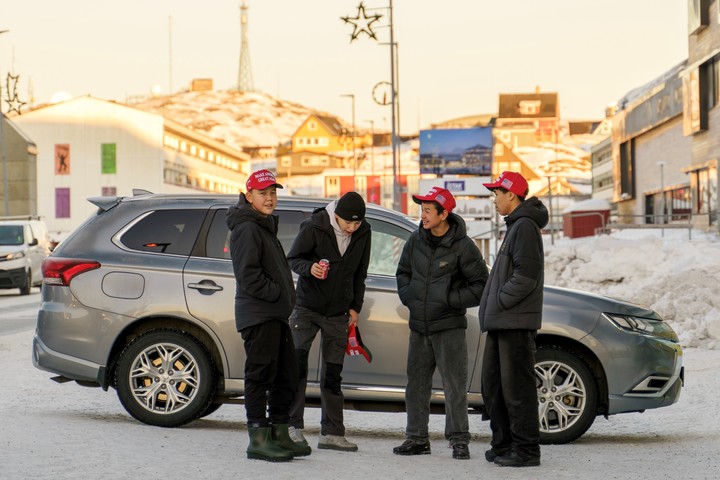 Los habitantes de Groenlandia, con los Gorrons rojos de la campaña de Donald Trump, se encuentran el martes en Nuuk. Foto: EFE